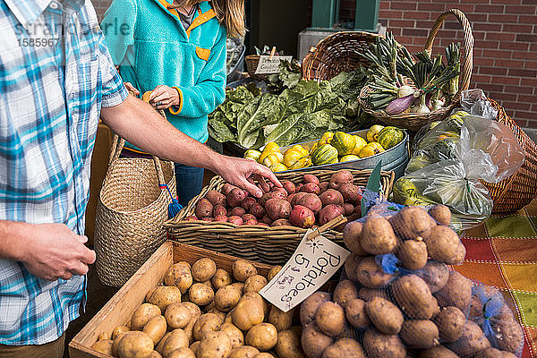 Mann und Frau sammeln Kartoffeln auf dem Bauernmarkt