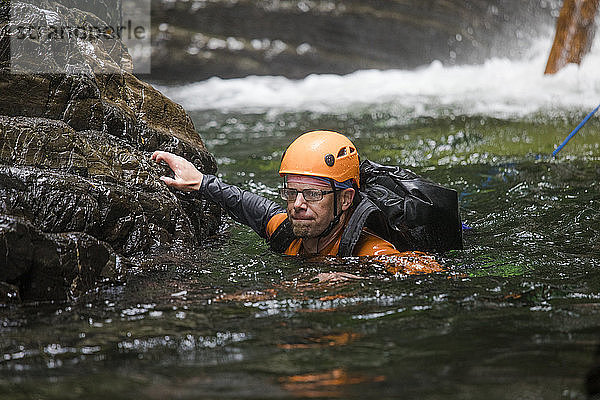 Mann schwimmt in Sicherheit  nachdem er sich in eine Schlucht abgeseilt hat.