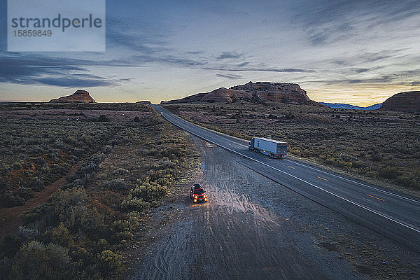 Einsame Straße in Utah am Abend mit einem angehaltenen Auto