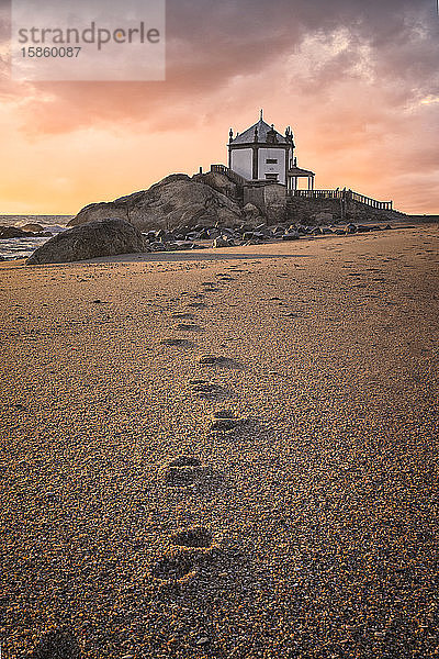 'Capela do Senhor da Pedra' bei Sonnenuntergang über dem Atlantik