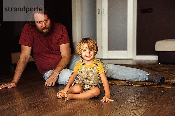 Vater mit kleinem Sohn spielt auf dem Boden