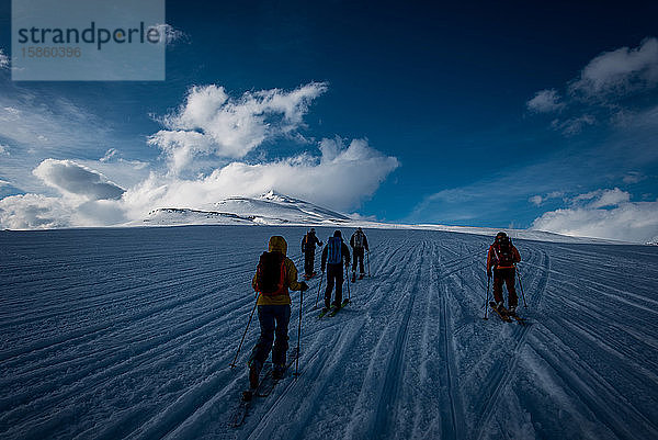 Eine Gruppe auf Skipisten in Richtung eines Berges