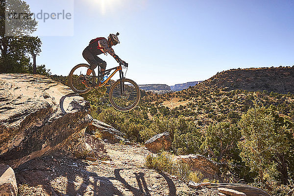 Ein Mann springt mit seinem Mountainbike auf einem Weg in Colorado.