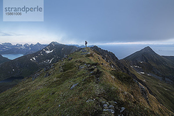 Wanderin überblickt Berglandschaft von Middagstind aus  FlakstadÃ¸y  Lofoten-Inseln  Norwegen