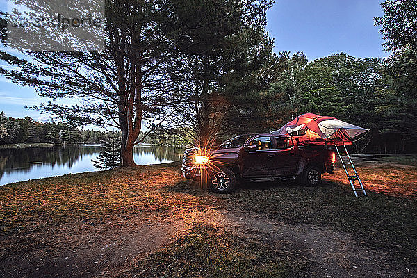 Pickup mit Zelt in der Abenddämmerung neben Penobscot River Maine geparkt
