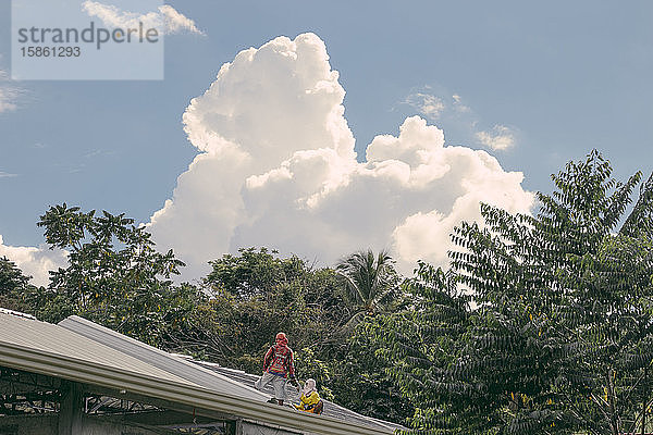 Maskierte Männer auf einem Blechdach im Freien an einem klaren Tag auf der Insel Samal