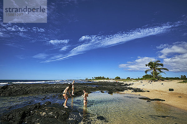 Drei Frauen spielen in einem Gezeitenbecken auf der großen Insel Hawaii
