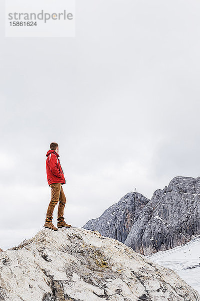 junger tausendjähriger Mann geniesst die Aussicht auf die Alpen auf einem Gletscher