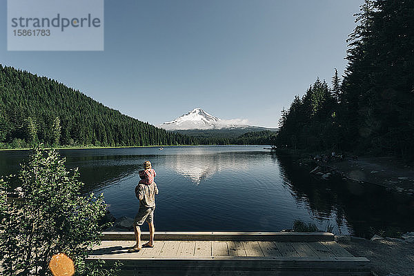 Ein Vater trägt seine Tochter am Trillium Lake  OR  auf den Schultern.