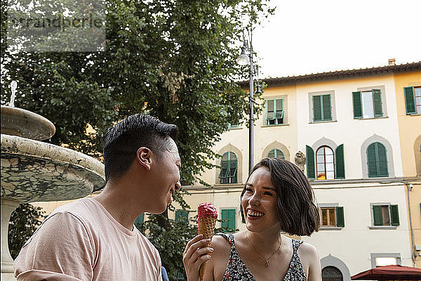 Verschiedenes lachendes Paar mit Gelato auf der italienischen Piazza