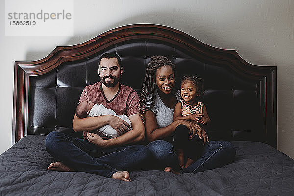 Multirassische Familie zusammen im Bett - Vater  Mutter  Kleinkind und 2 Jahre alt