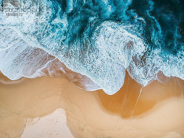 Drohnen-Luftaufnahme der Meeresbrandung am leeren Strand blau