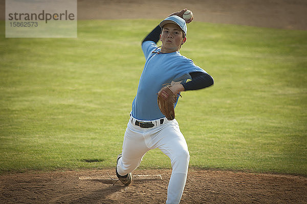 Pitcher in hellblau-weißem Trikot beim Aufziehen auf ein Baseballfeld.