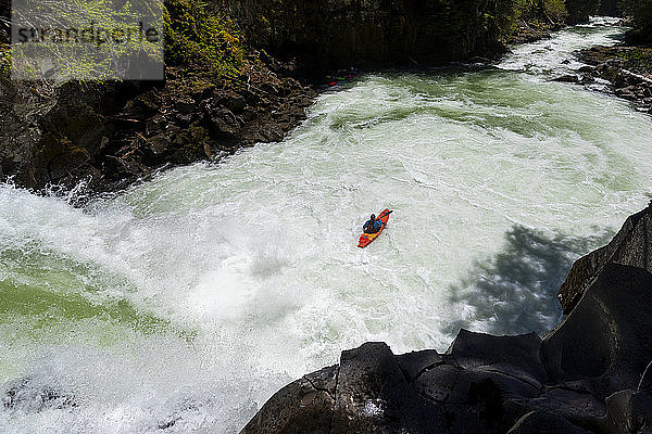 Ein Wildwasser-Kajakfahrer paddelt über einen Wasserfall am Callaghan Creek