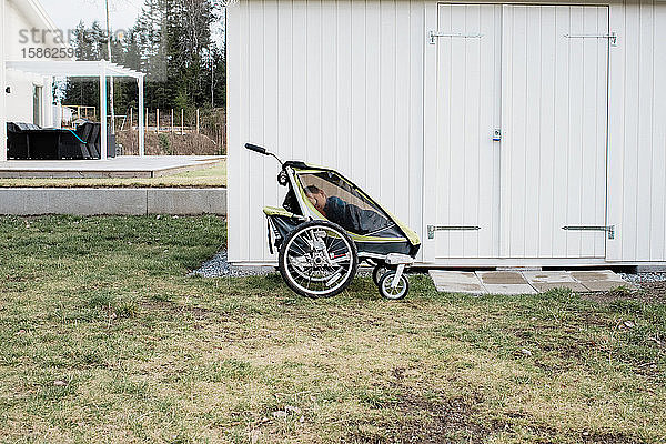Kind schläft in einem Kinderwagen draußen in Schweden