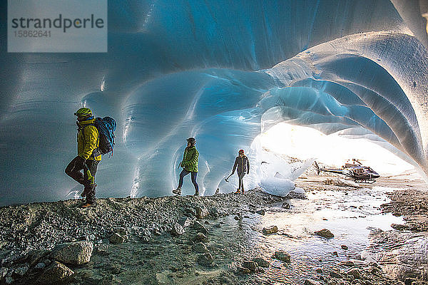 Abenteuerführerin bringt zwei Klientinnen in eine Gletscherhöhle.