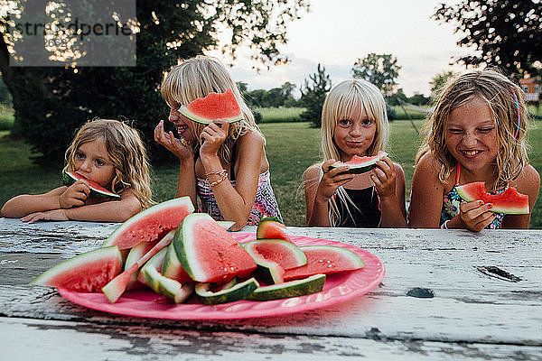 Geschwister haben im Sommer Spaß beim Wassermelonenessen im Freien