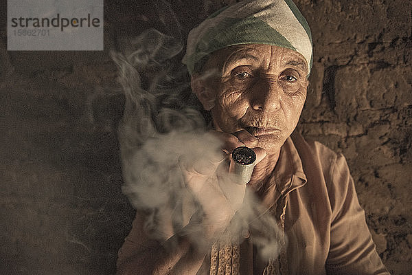 Alte Frau raucht Pfeife in ihrem Haus im Norden Brasiliens