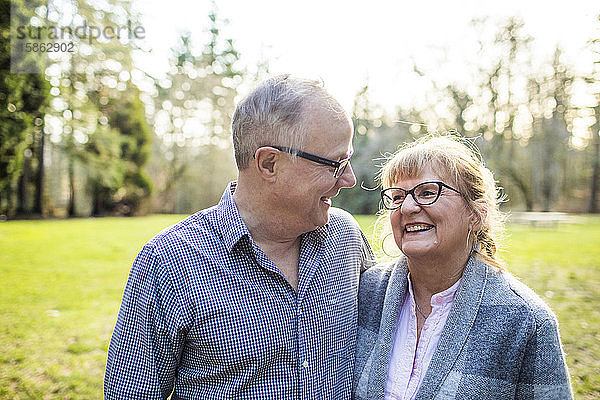 Ein süßes älteres Paar  das im Freien zusammen lacht und lächelt.