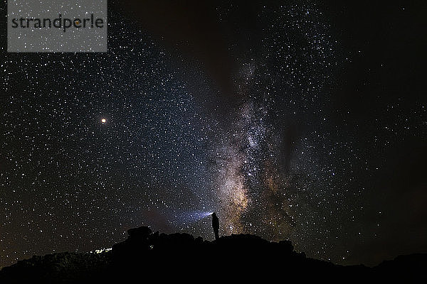 Silhouette eines Bergsteigers mit Blick auf die Milchstraße