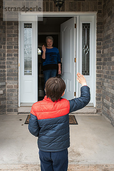 Besuch der sozialen Distanz zwischen dem Jungen und seiner Großmutter zu Hause.