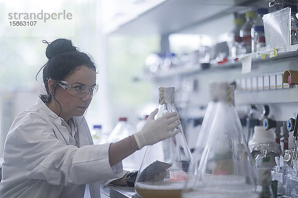 junge Wissenschaftlerin mit Tablette in einem Labor