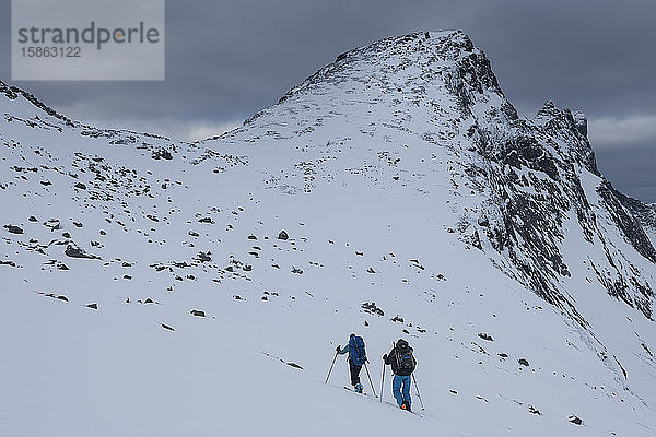 Zwei Skitourengeher nahe dem Gipfel des Branntuva  Lofoten  Norwegen