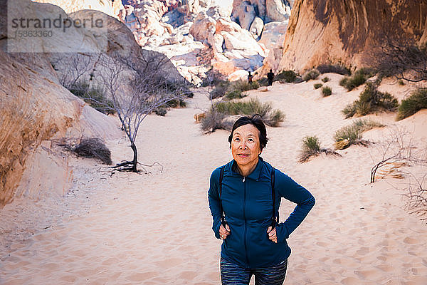 Ältere asiatische Frau wandert in der Wüstenlandschaft