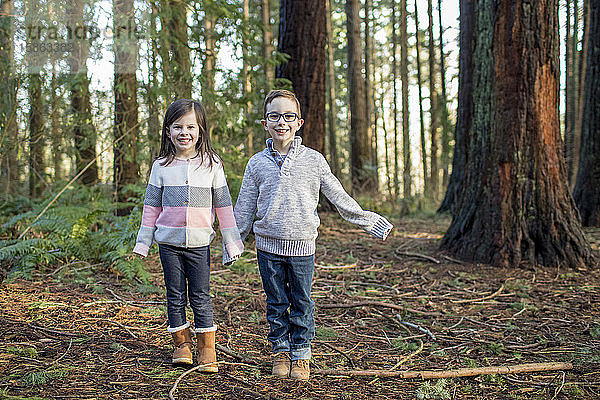 Bruder und Schwester spielen im Wald.