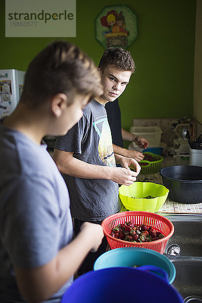 Zwei junge Männer bereiten in der Küche Essen vor