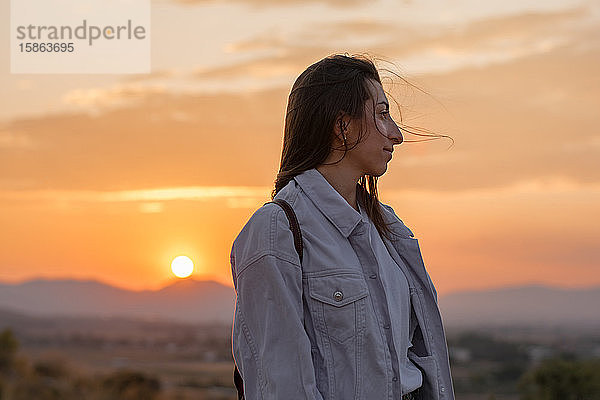 Junge Abenteurerin bei Sonnenuntergang auf einem Berg. Lebensstilkonzept  Porträt