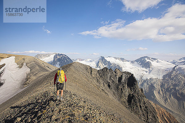 Rückansicht einer Backpacker-Wanderung auf einem felsigen Gipfelgrat.