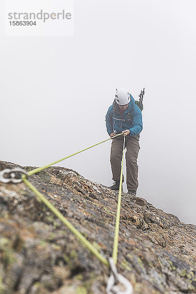 Draufsicht eines Bergsteigers beim Abseilen am Berghang.