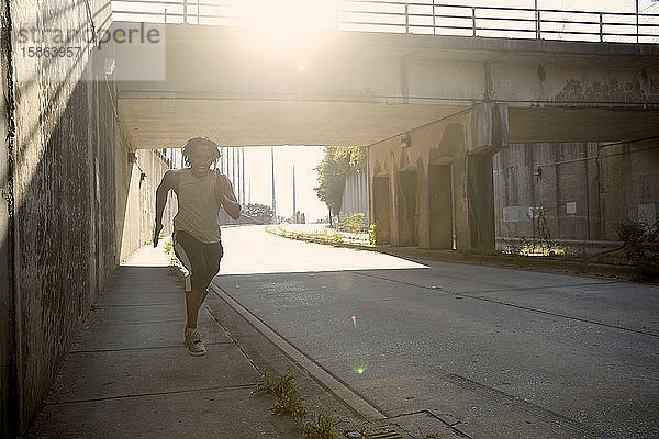 Afroamerikanischer Mann rennt auf Bürgersteig