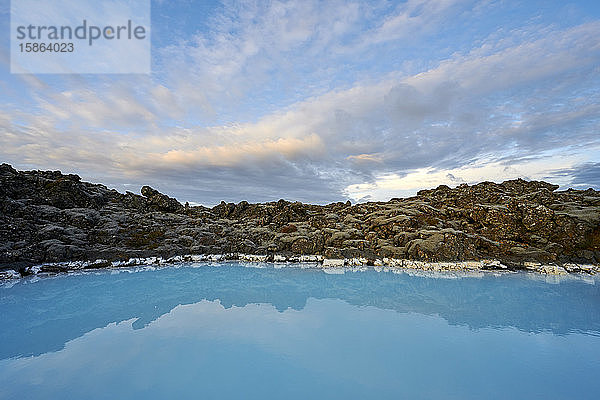 Malerische Landschaft einer geothermischen Lagune mit felsiger Küste bei bewölktem Himmel