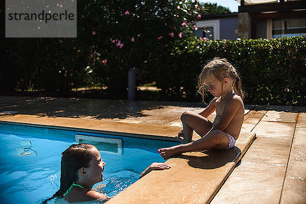 Zwei Schwestern schwimmen im Pool