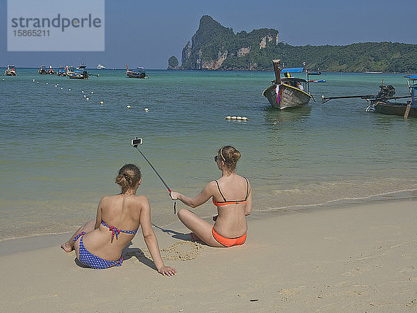 Westliche Touristinnen machen ein Selfie-Foto am Strand der Phi Phi Inseln  Andamanisches Meer  Thailand  Südostasien  Asien