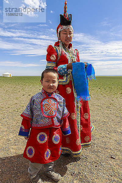 Frau und Kind in traditioneller Kleidung (Deel)  Silberschüssel für Milchgruß  in der Nähe des Ger  Wüste Gobi  Bulgan  Omnogov  Mongolei  Zentralasien  Asien