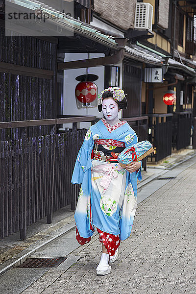 Maiko  Geisha-Lehrling  geht zur abendlichen Verabredung vorbei an traditionellen Teehäusern aus Holz  Gion  Kyoto  Japan  Asien