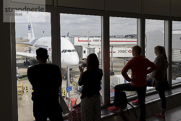 Menschen  die durch ein Fenster auf einen Airbus A380 der Malaysia Airlines am internationalen Flughafen Kuala Lumpur  Malaysia  Südostasien  Asien  schauen