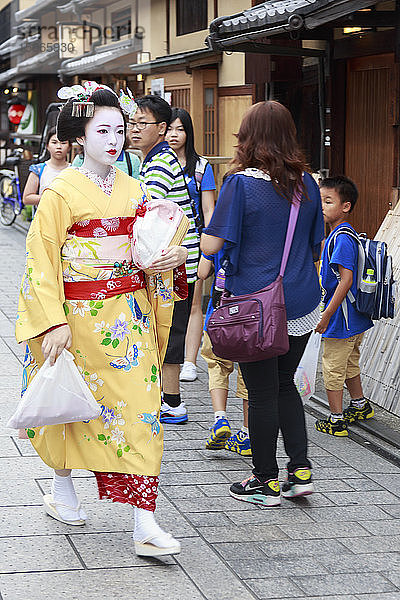Maiko  Geisha-Lehrling  geht zur Abendverabredung durch die Touristenmenge  Hanami-koji-Straße  Gion  Kyoto  Japan  Asien