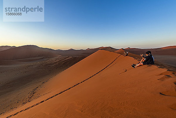 Touristen genießen den Sonnenaufgang von der Düne 45  Sossusvlei  Namib-Wüste; Namibia