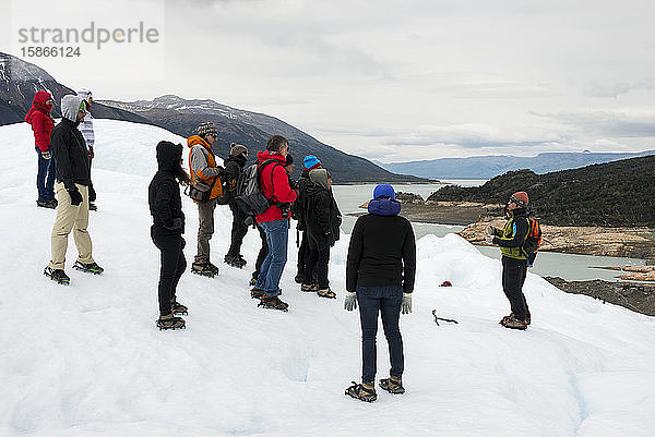 Touristen hören einem Führer zu  während sie auf einem Gletscher im Los Glaciares National Park stehen; Provinz Santa Cruz  Argentinien