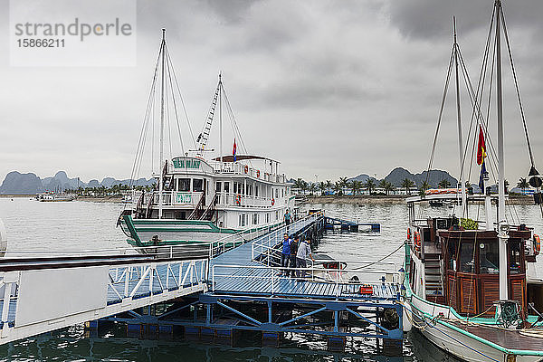 Ausflugsboot und Fischerboot an einer Anlegestelle in der Ha Long Bay; Provinz Quang Ninh  Vietnam