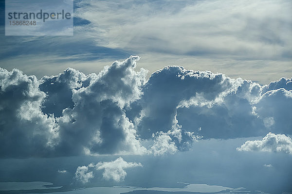 Im Sonnenlicht glühende Wolken am Himmel und Seen am Boden; Belize