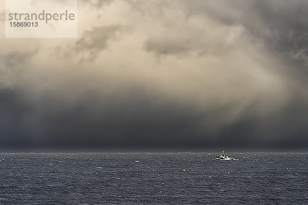 Stürmischer Himmel über dem Meer und ein Boot im offenen Wasser vor der Küste von South Shields; Tyne and Wear  England