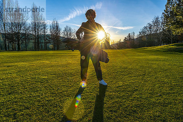 Golferin im Gegenlicht der Sonne; Schweiz