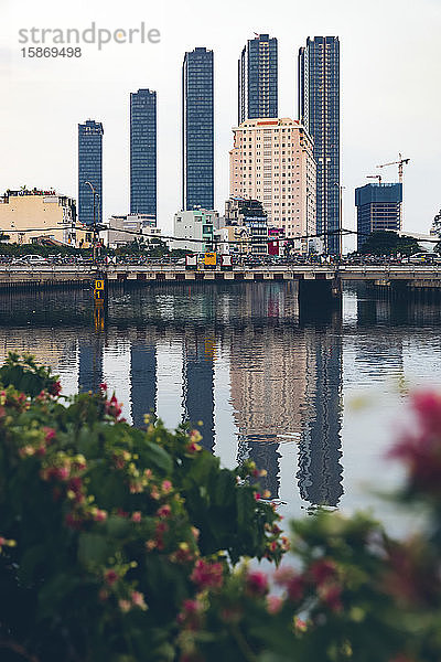 Aufgereihte Wolkenkratzer bilden die Skyline und spiegeln sich im Wasser des Saigon-Flusses; Ho-Chi-Minh-Stadt  Vietnam