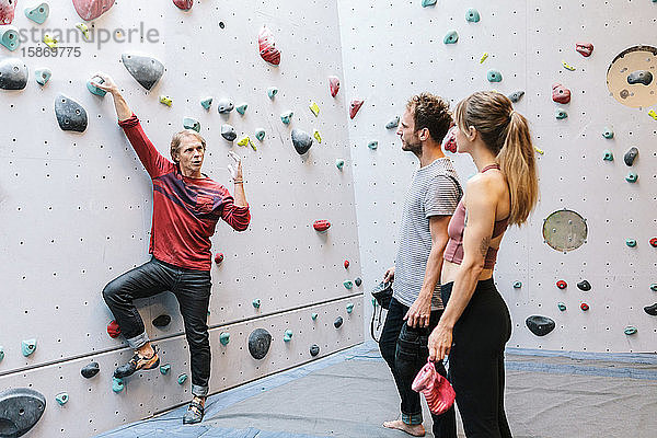 Ausgereifter Ausbilder  der die Schüler im Fitnessstudio über das Bouldern unterrichtet