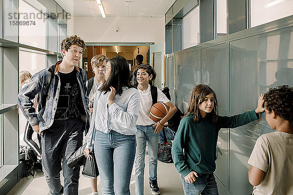 Männliche und weibliche Schüler sprechen in der Pause auf dem Schulkorridor